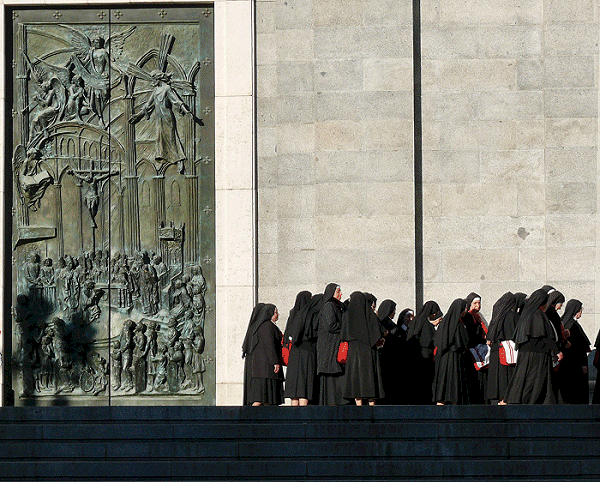 Rij wachtende nonnen voor deur kathedraal